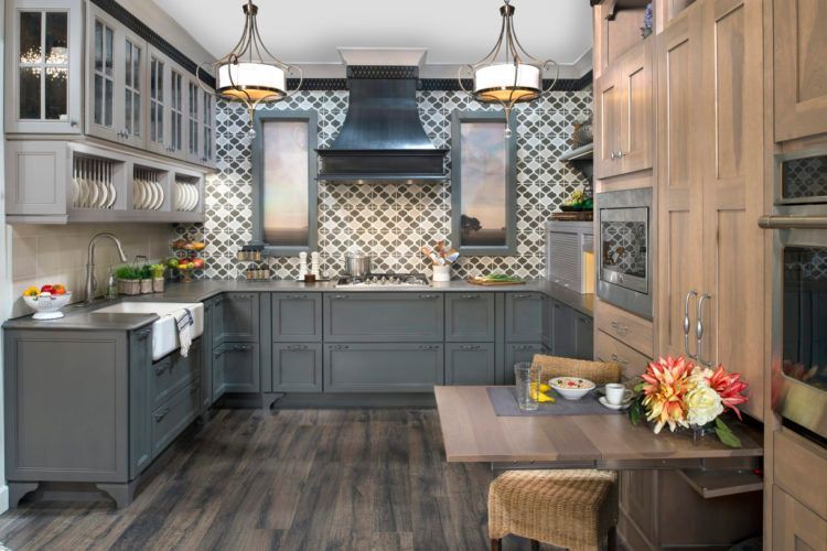 Modern kitchen with blue cabinets, patterned tile backsplash, island, and pendant lights