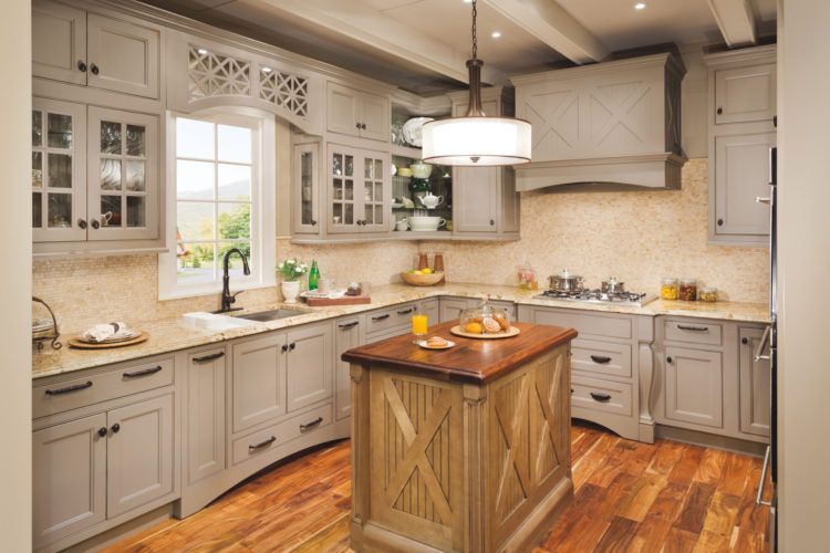 Bright kitchen with gray cabinets, wood island, white backsplash, and hardwood floors