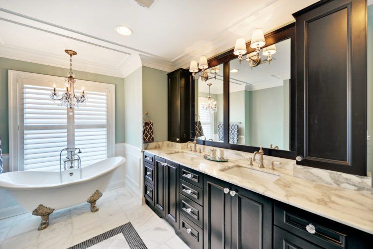 Elegant bathroom with a freestanding tub, double vanity, and large mirror in a bright, modern interior