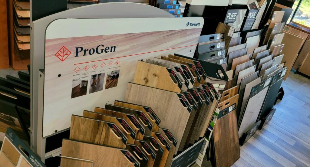 A flooring showroom display with sample boards and a large ProGen sign behind them.
