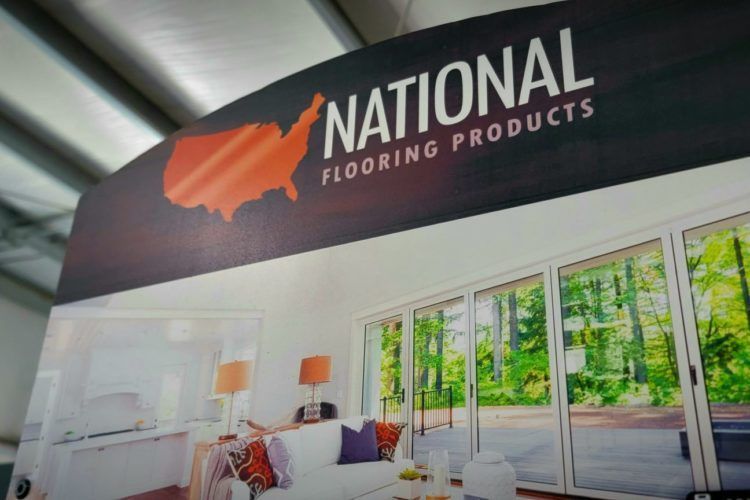 National Flooring Products showroom banner above a modern living room display with large windows
