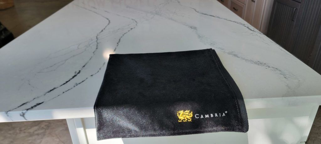 Black folded cloth with a yellow logo on a white marble tabletop