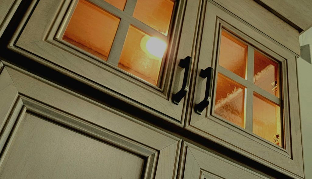 Tilted view of beige building windows glowing with warm orange light at dusk