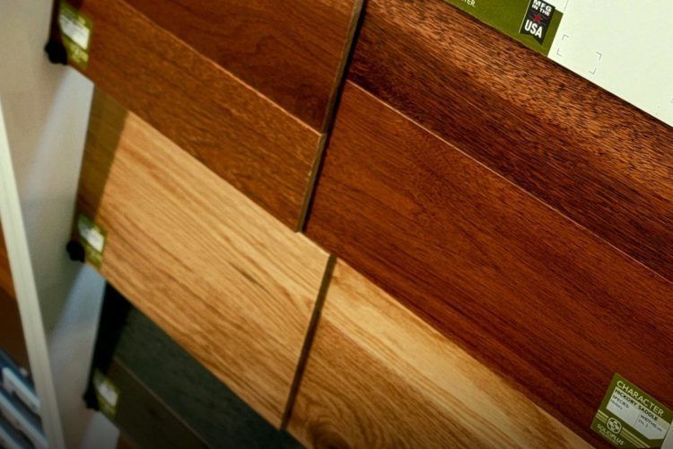 Wooden cabinet doors with different wood finishes and brass hinges closed together.