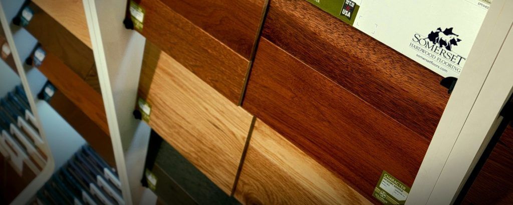 Rows of wooden window blinds in white frames, shown close-up at an angle.