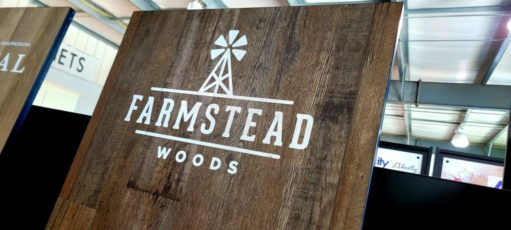 Farmstead Woods sign on a rustic wooden board in an indoor market setting