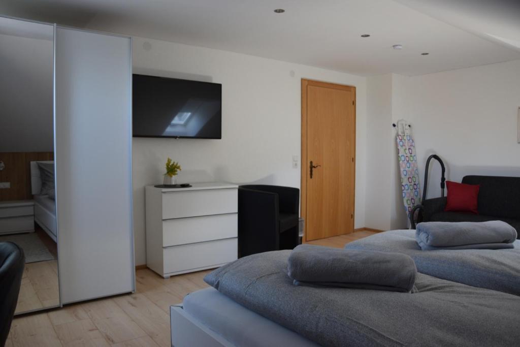 Schlafzimmer mit Fernseher, Betten und Kommode