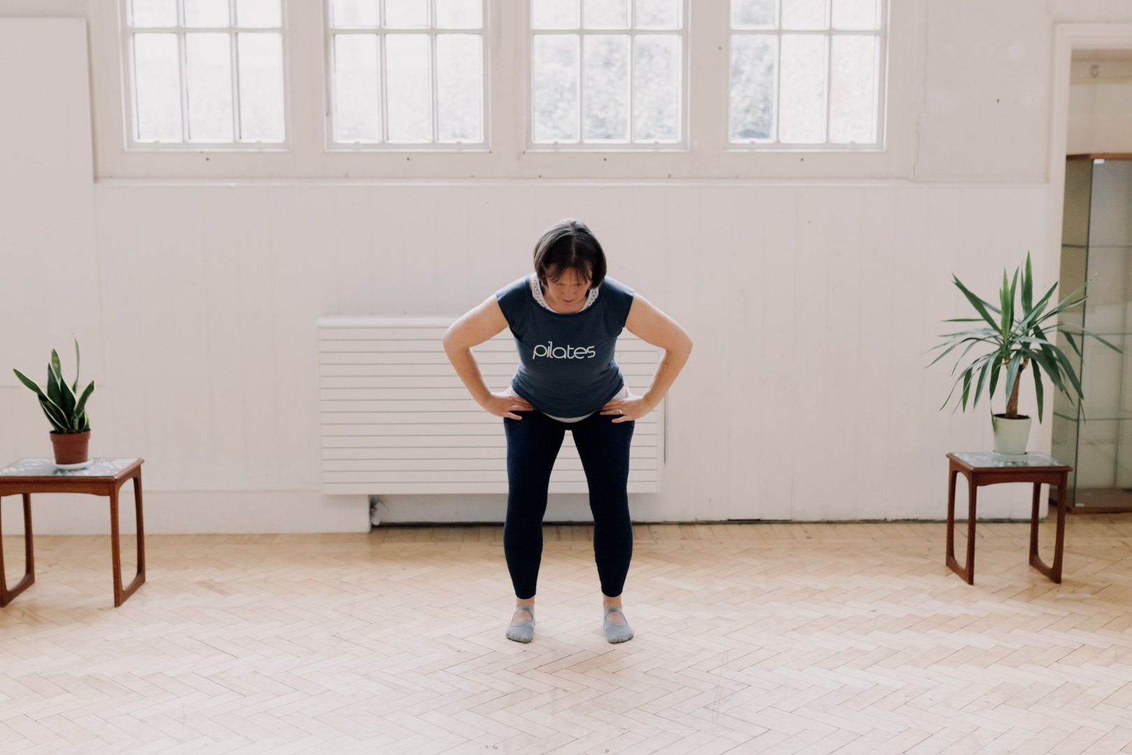 photo of a lady in sports clothes doing a squat movement