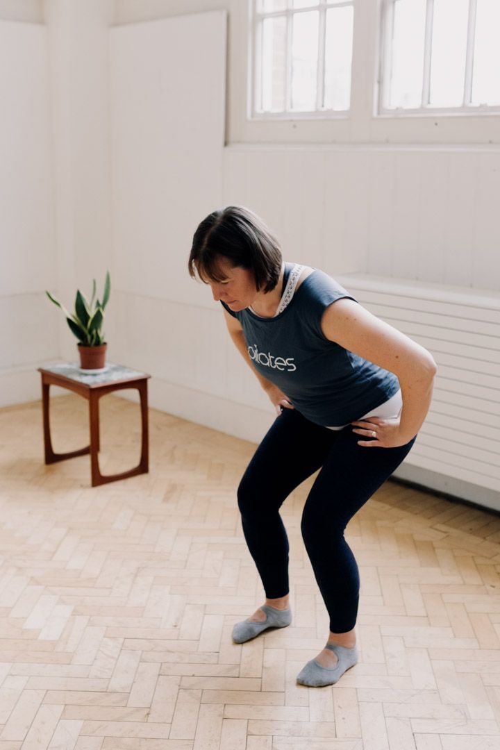 photo of a lady from the side doing a squat movement