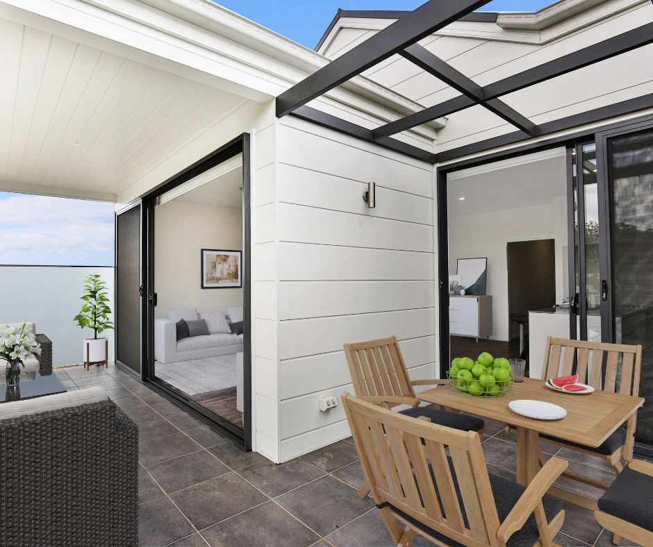 Modern patio with outdoor dining table, wicker seating, and an open bedroom beside a covered walkway