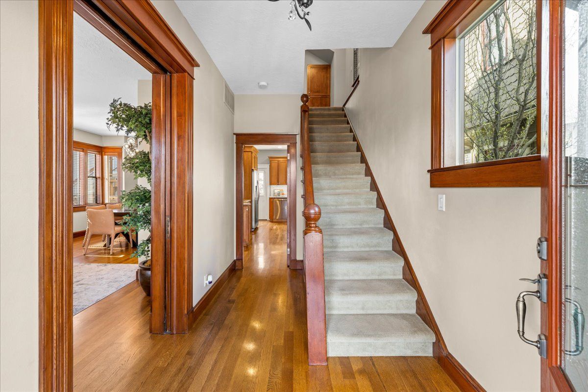 A hallway with stairs leading up to the second floor of a house