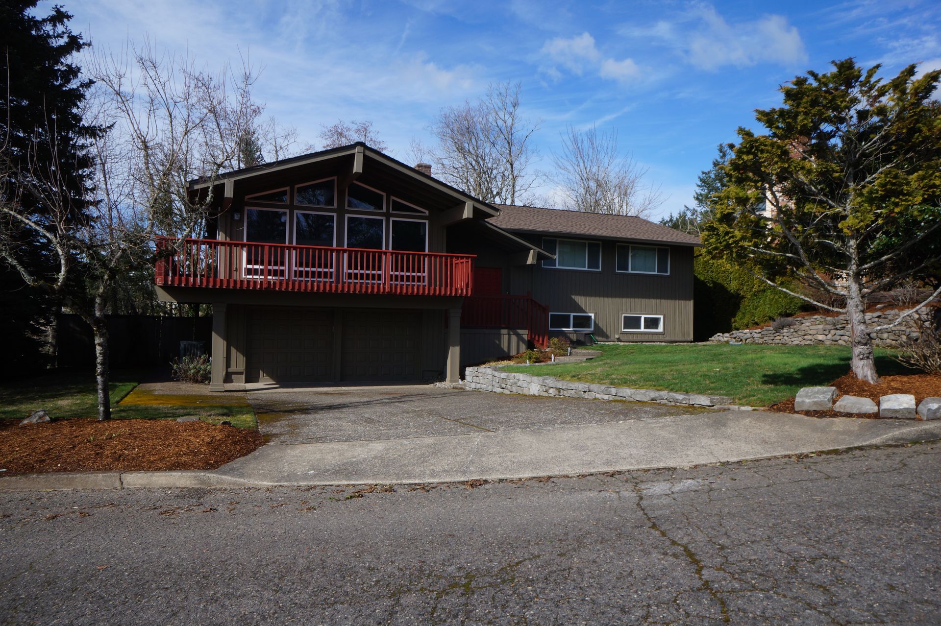 A large house with a red deck and a garage