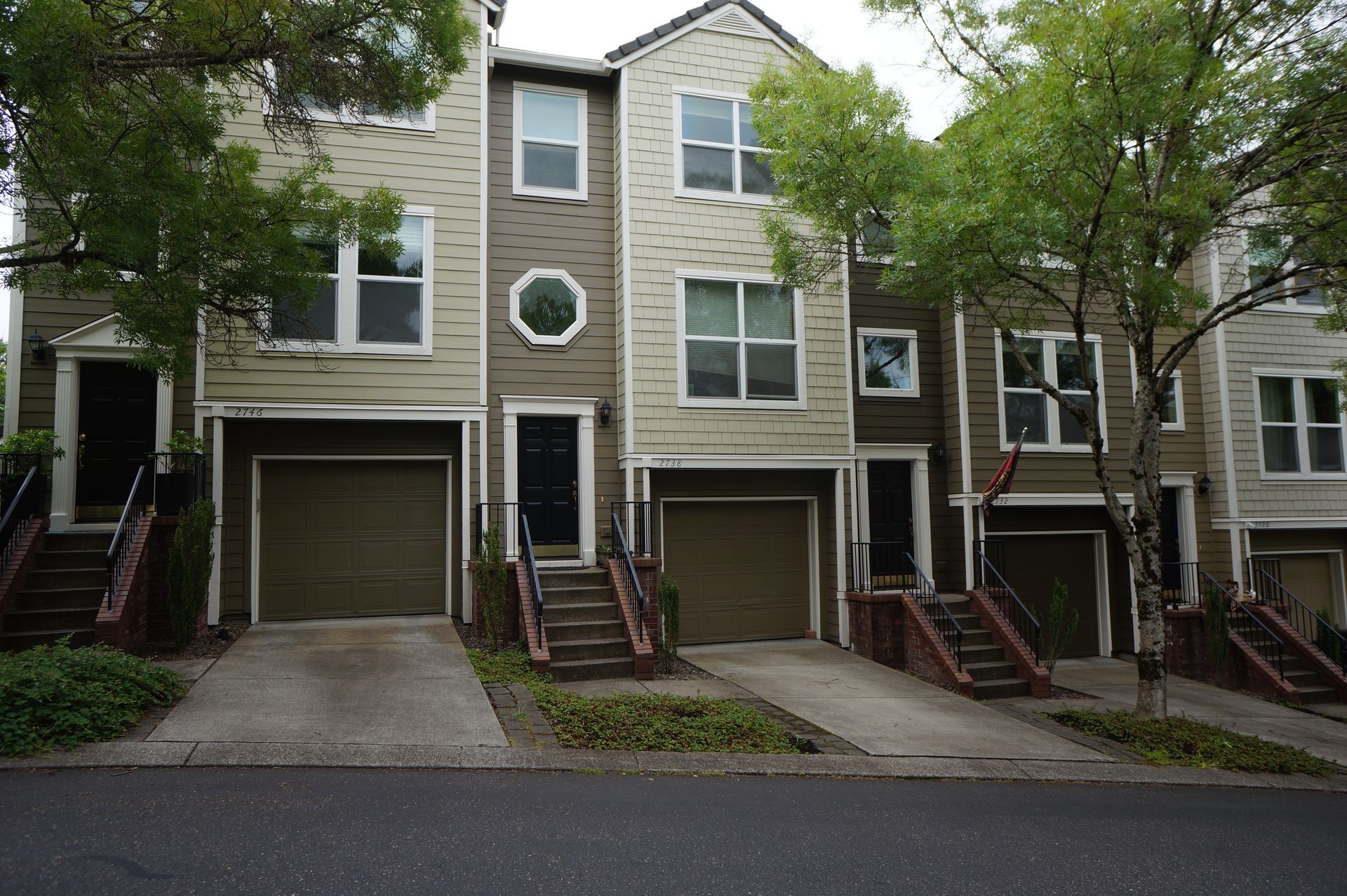 A row of houses with garages and stairs in front of them
