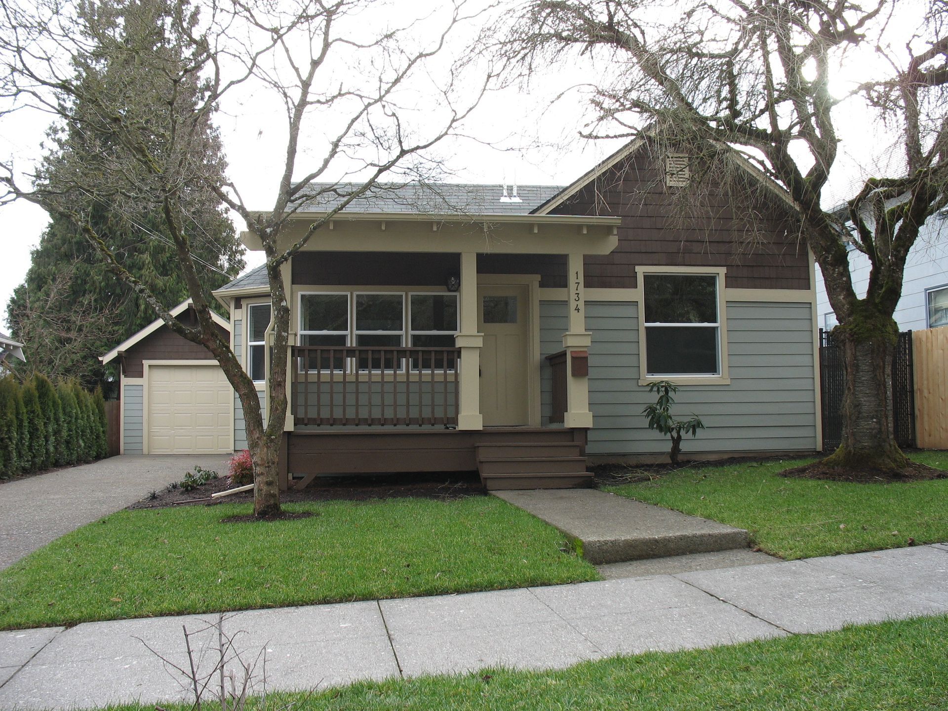 A small house with a porch and a garage
