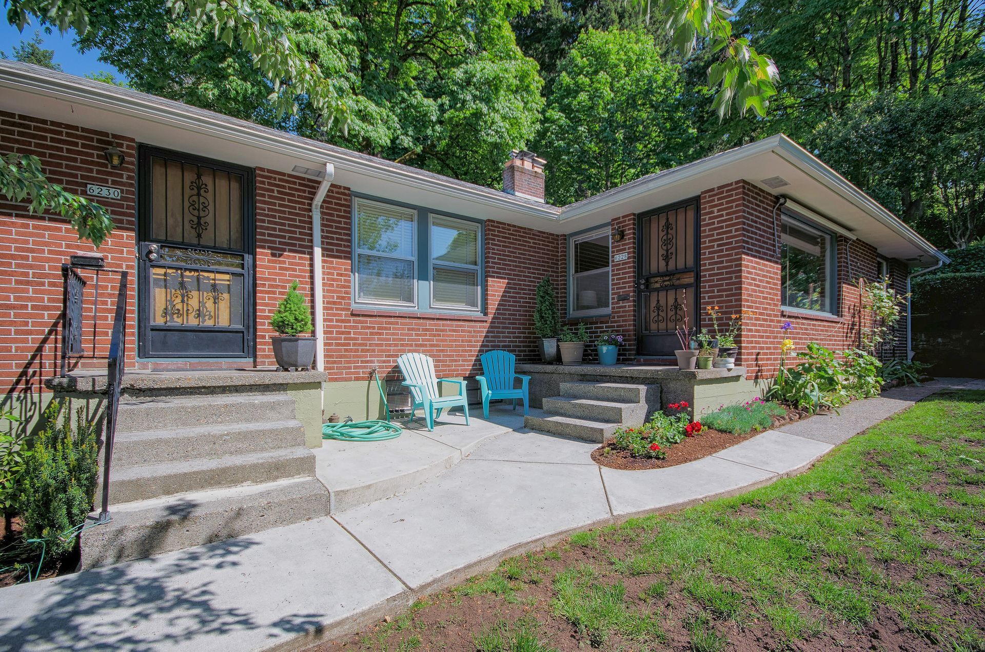 A brick house with a patio and chairs in front of it.