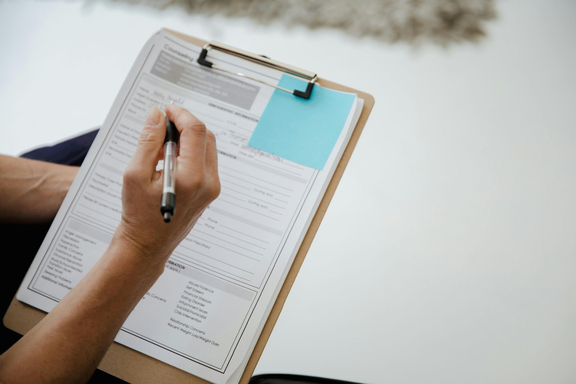 A person is completing doctor's forms on a clipboard