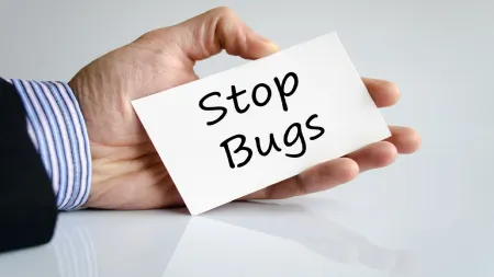 A person is holding a card that says stop bugs