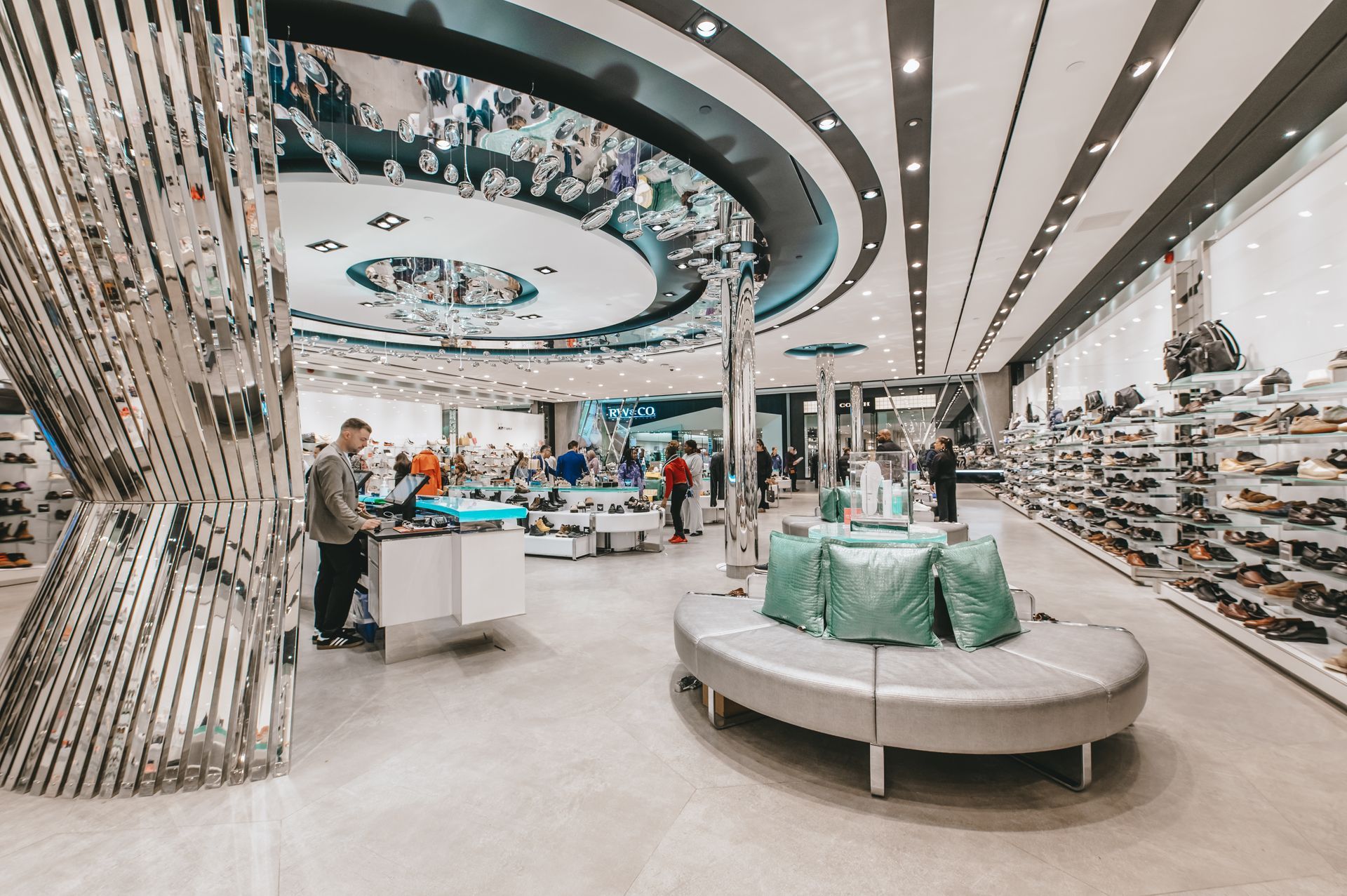 Un homme se tient à un comptoir dans un magasin de chaussures.