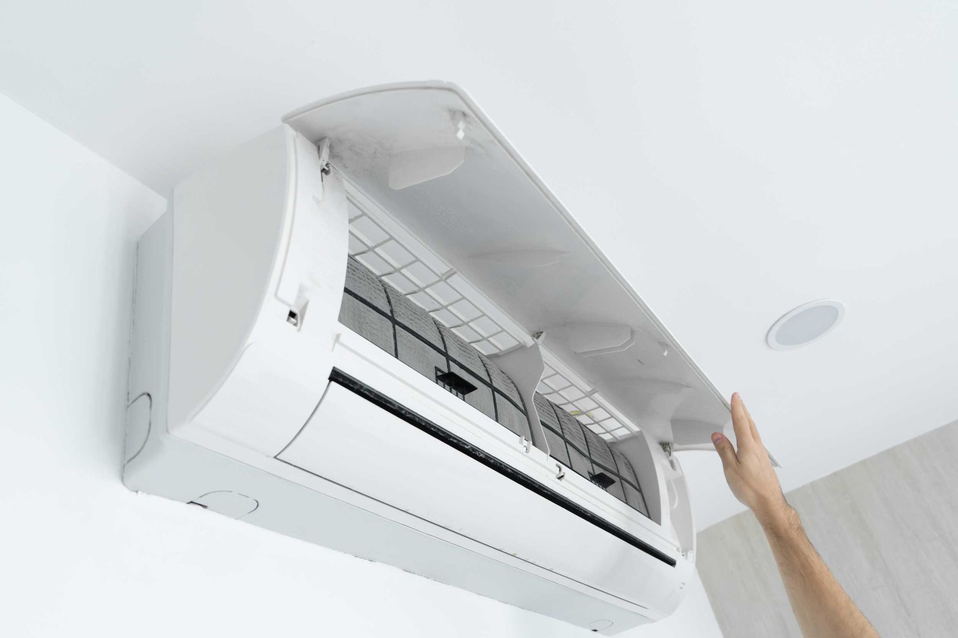 A man is opening an AC unit. A man is opening an AC unit.