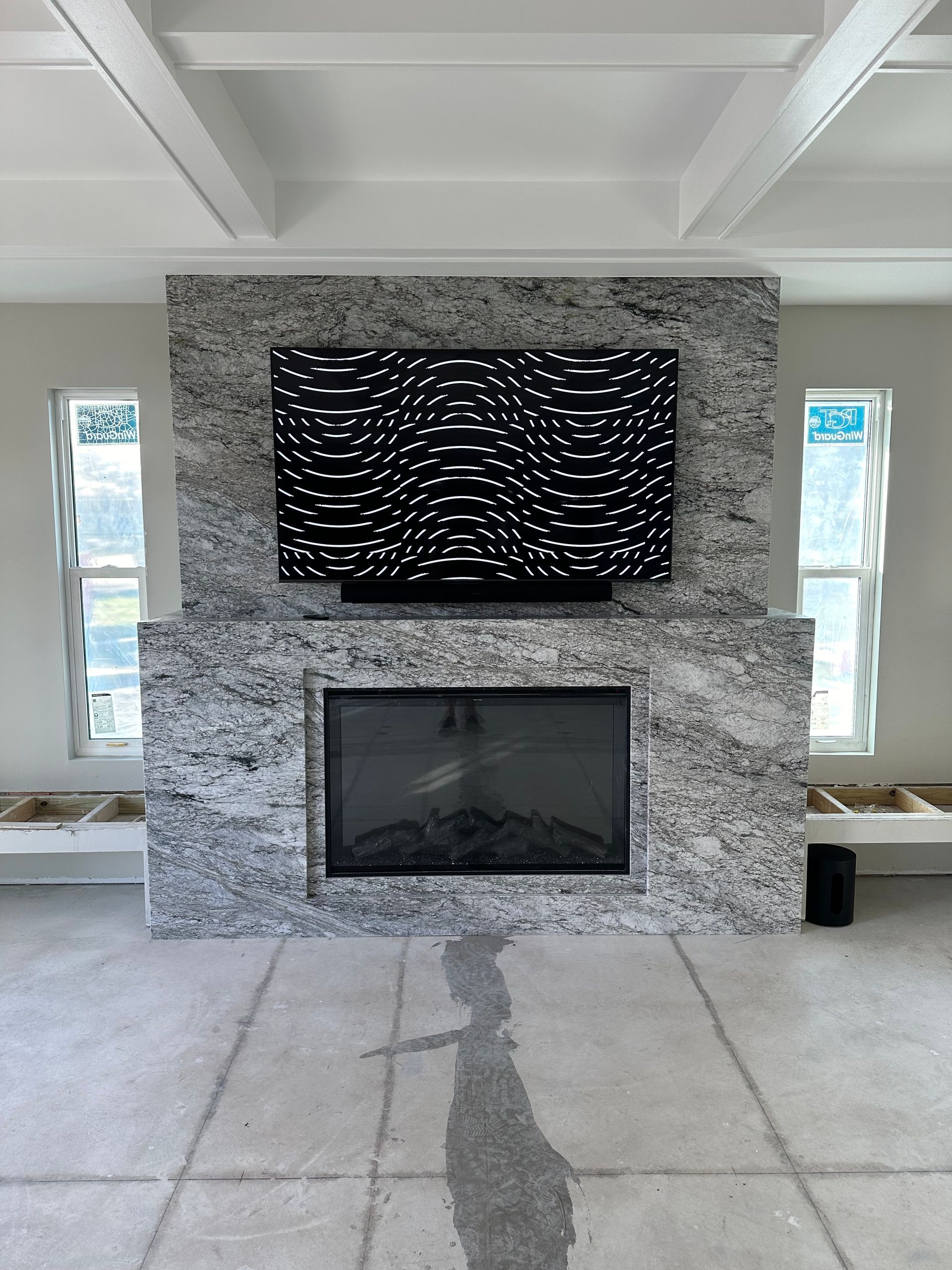 A living room with a fireplace and a flat screen tv on the wall.