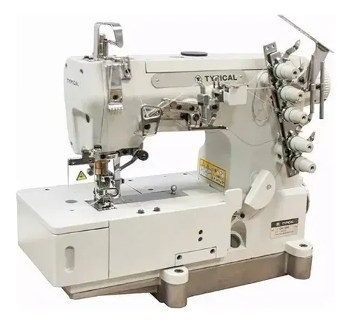 Una máquina de coser industrial de puntada de recubrimiento de la marca Typical, de color blanco, sobre un fondo neutro.