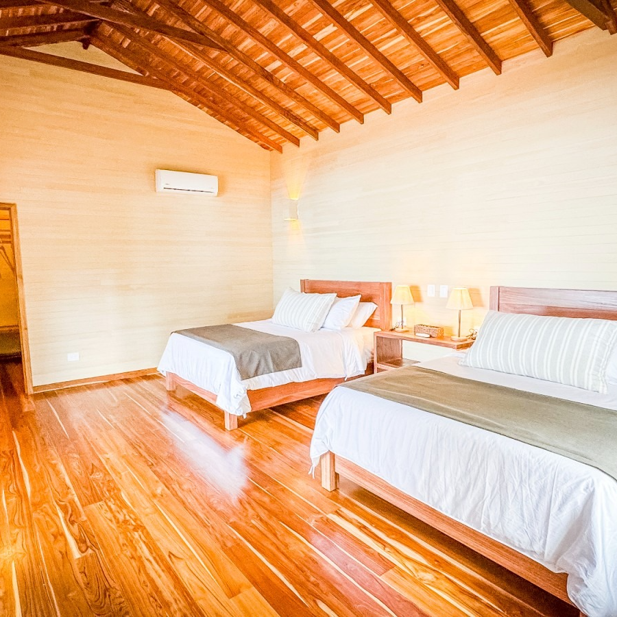 A hotel room with two beds and a wooden floor