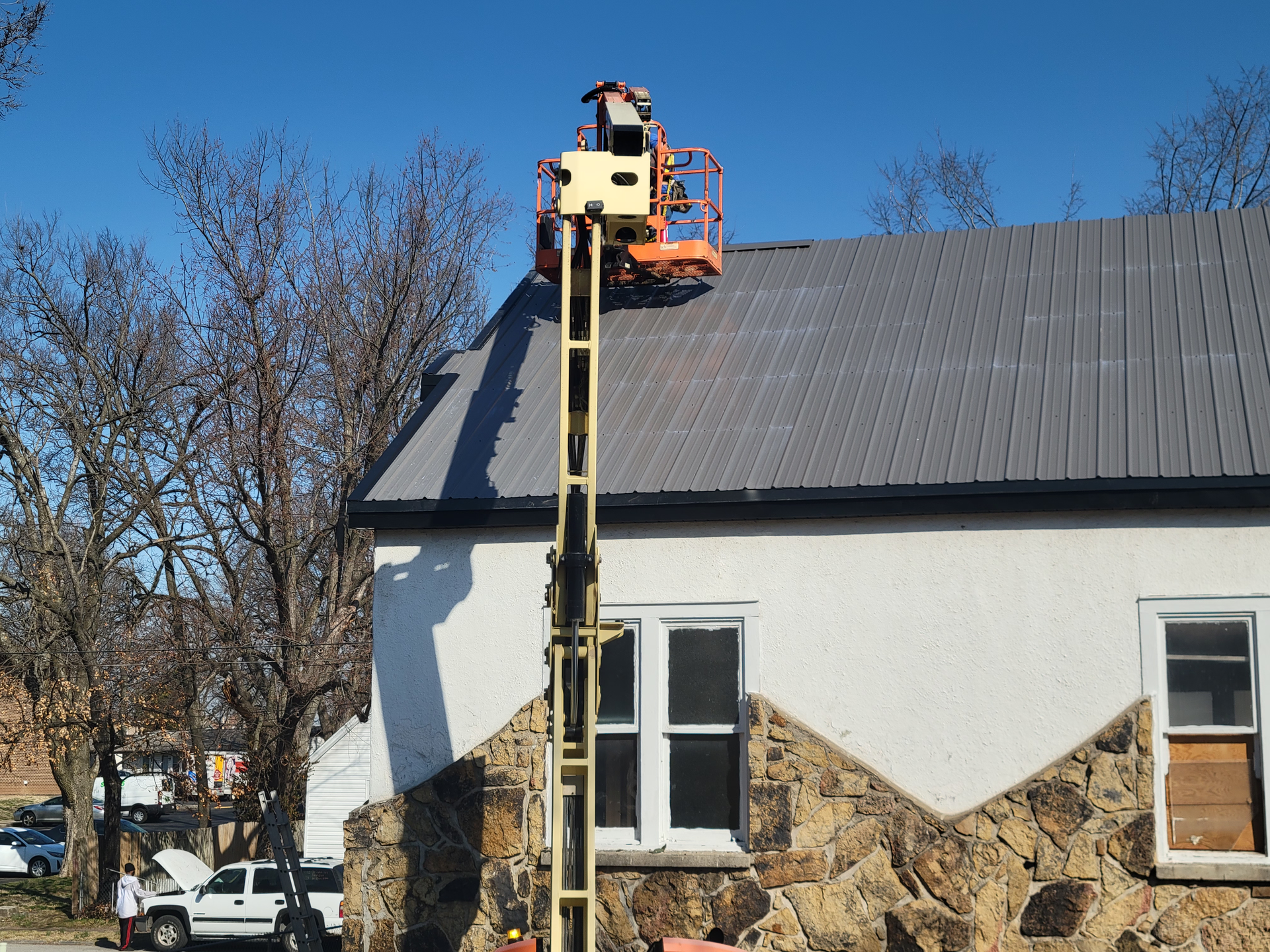 White flat roof with four dark rectangular skylights near shingled roof edges White flat roof with four dark rectangular skylights near shingled roof edges