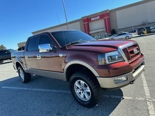Dark Red Truck with an extended cab with windshield and side windows tinted.