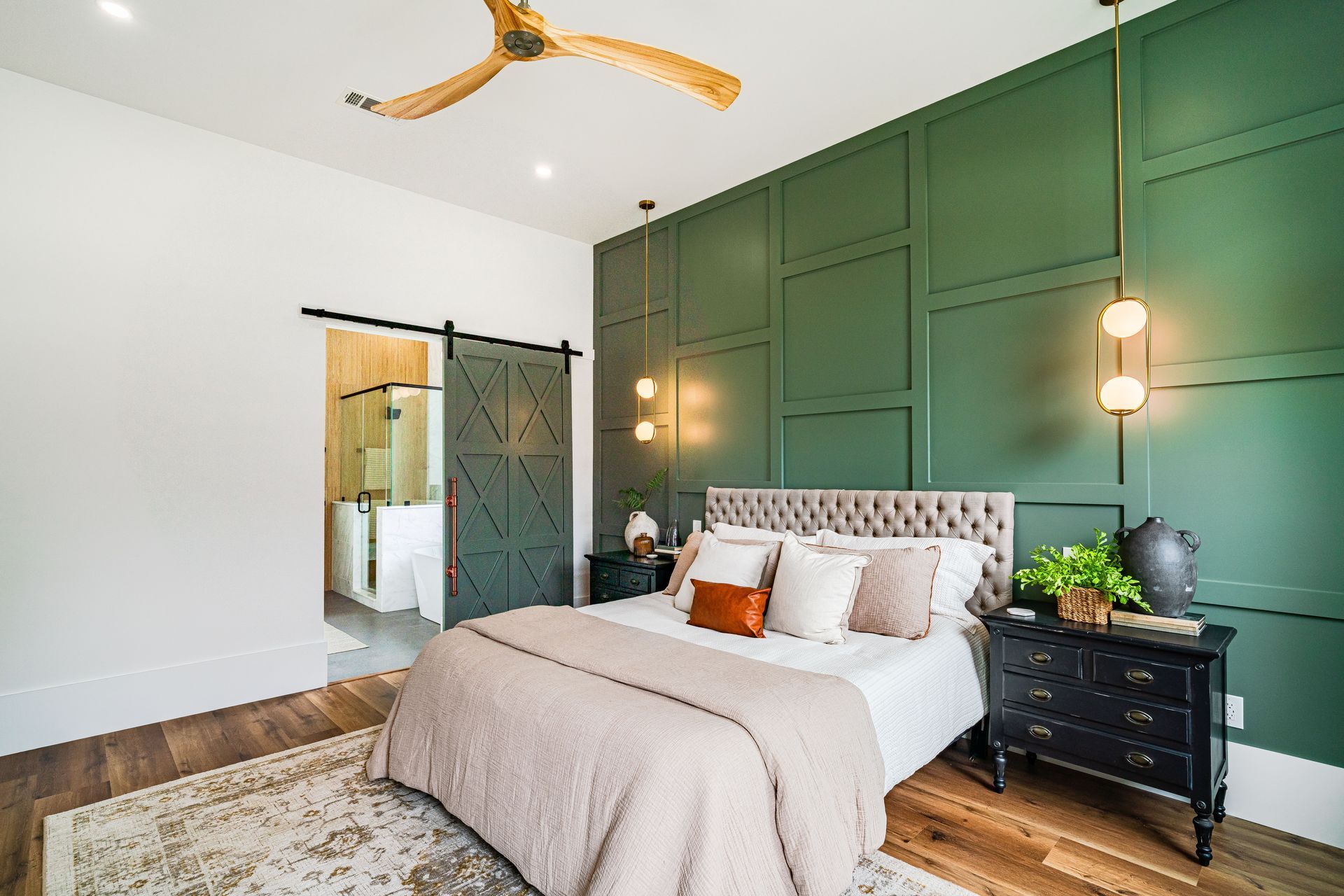 Green board-and-batten accent wall in a bedroom with custom wood paneling