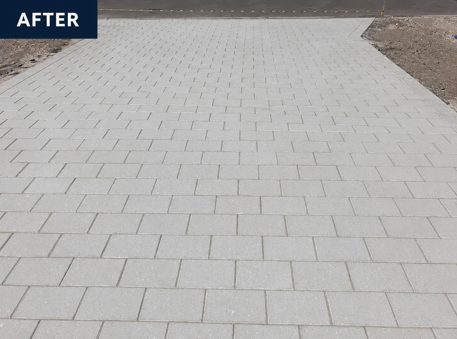 New light-gray paver driveway labeled “AFTER,” bordered by dark asphalt and gravel.