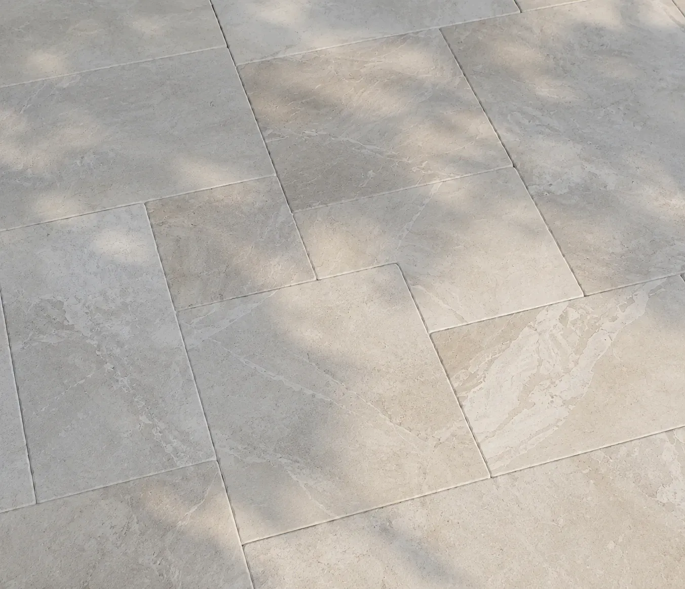 Light gray stone pavement with rectangular tiles and subtle shadows.