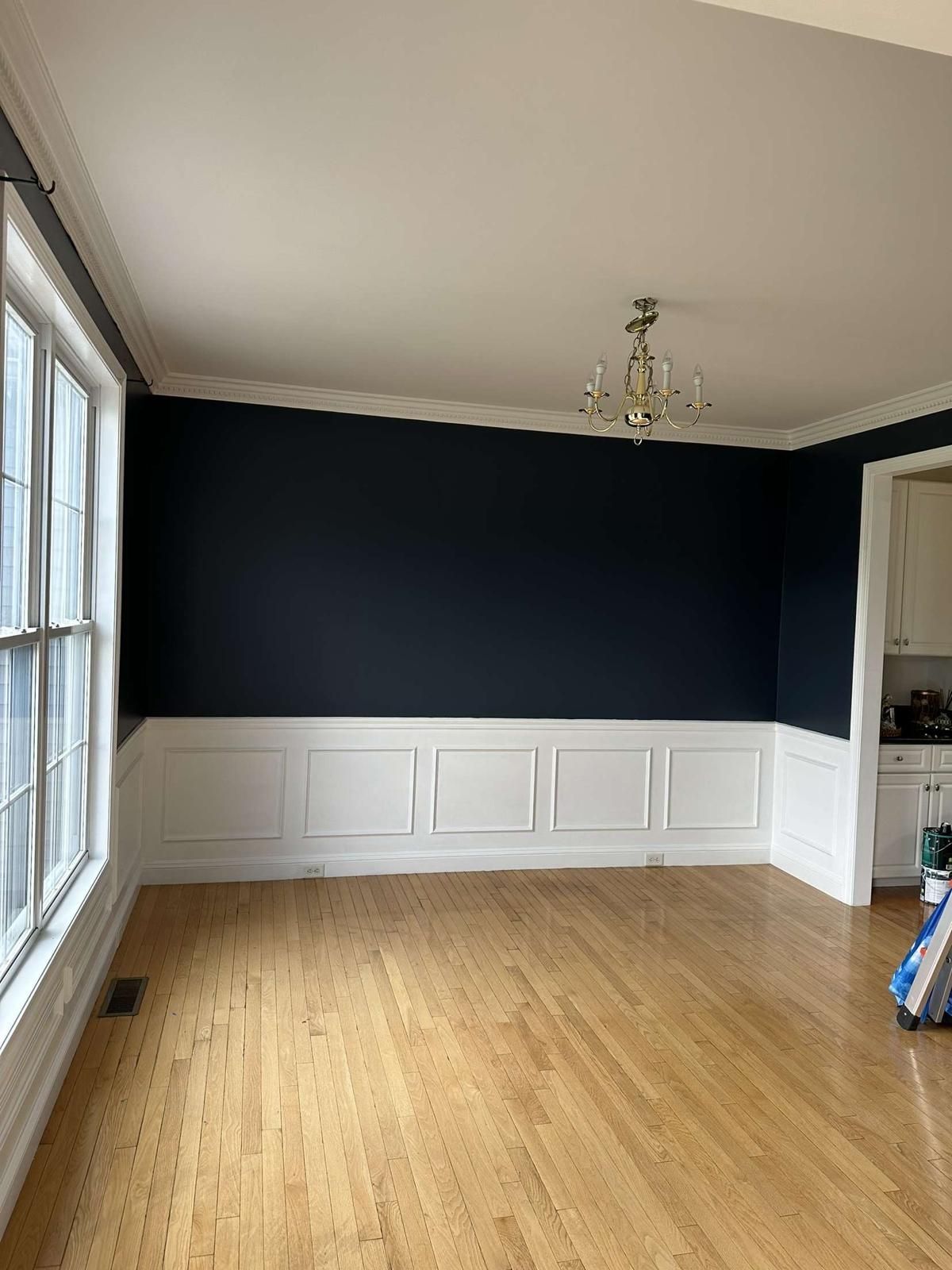 A living room with dark blue walls and wooden floors.
