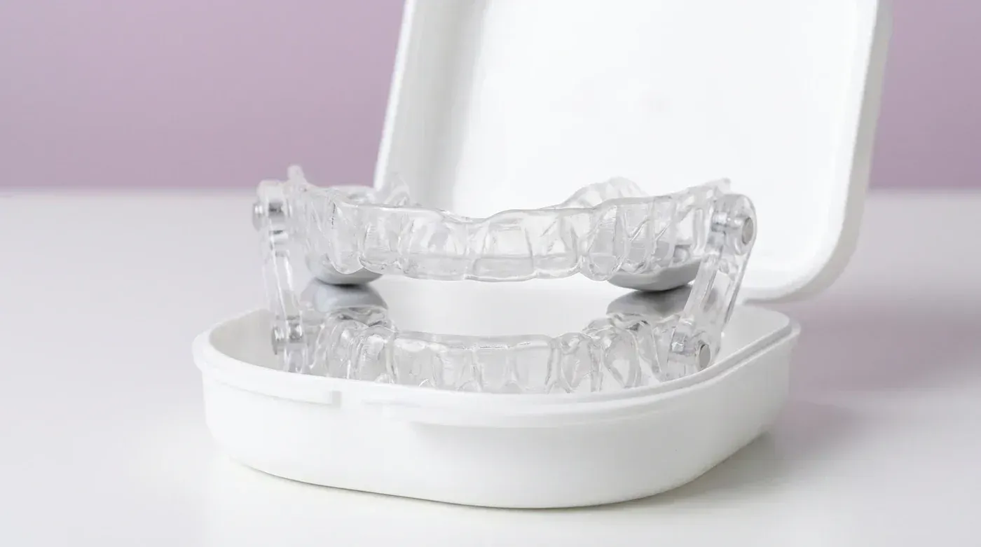 A clear custom oral sleep appliance in its case, used to treat snoring and sleep apnea