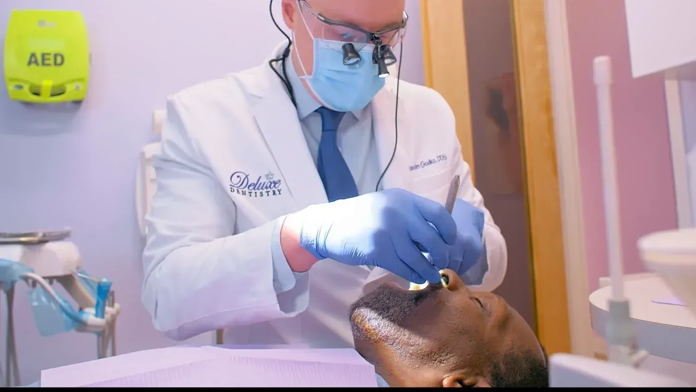 Dr. Godko in surgical loupes re-checking a patient’s gums after a deep cleaning