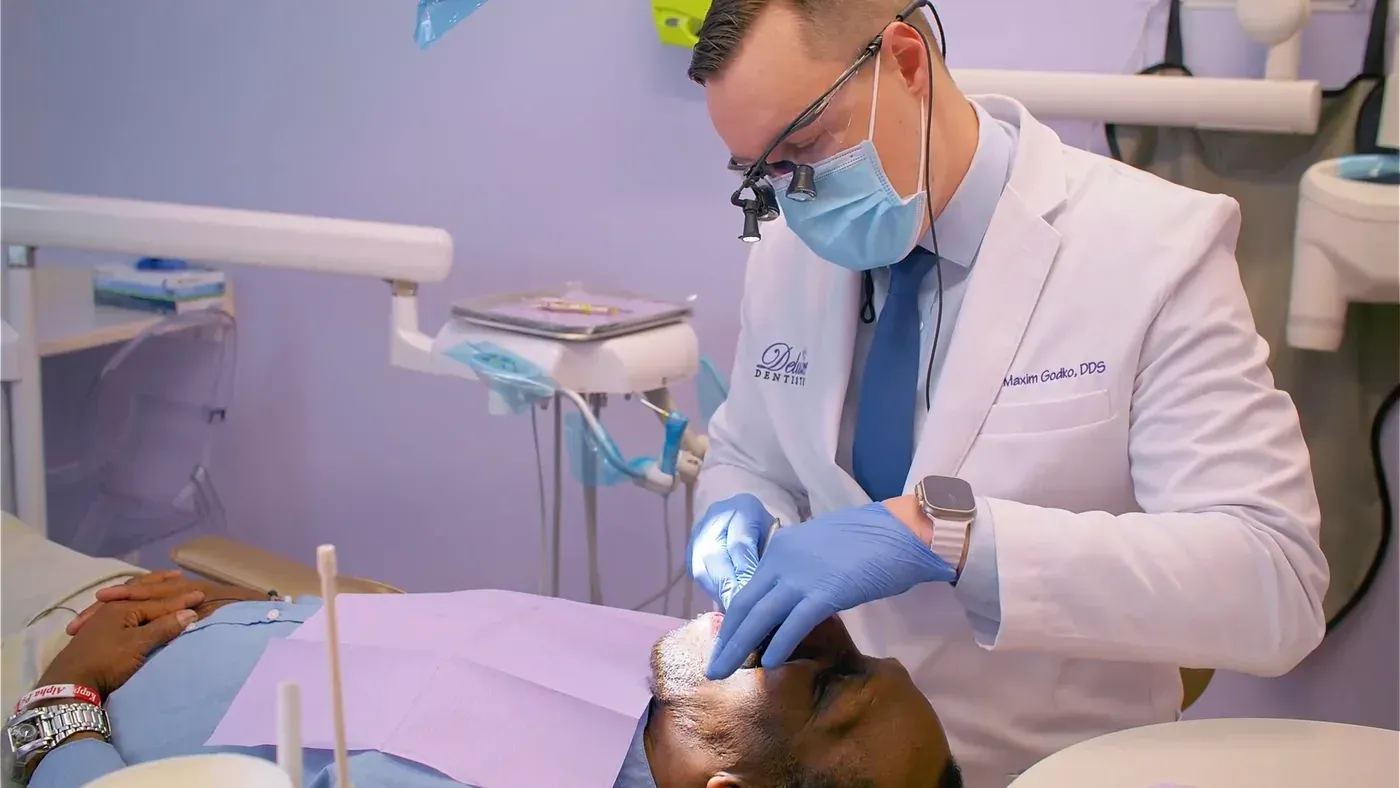 Dr. Maxim Godko working under magnifying loupes to repair a chipped tooth with dental bonding