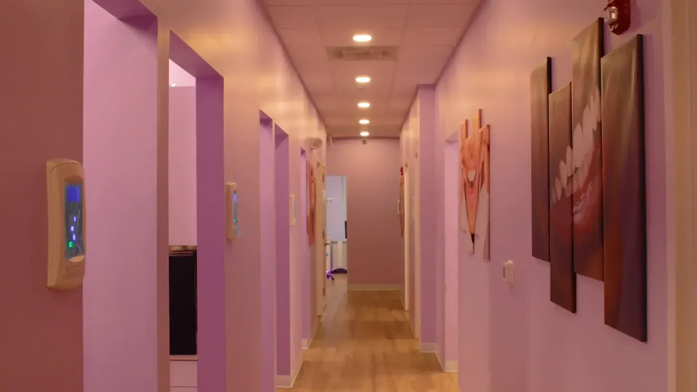 Office hallway lined with smile artwork leading to the smile makeover treatment rooms