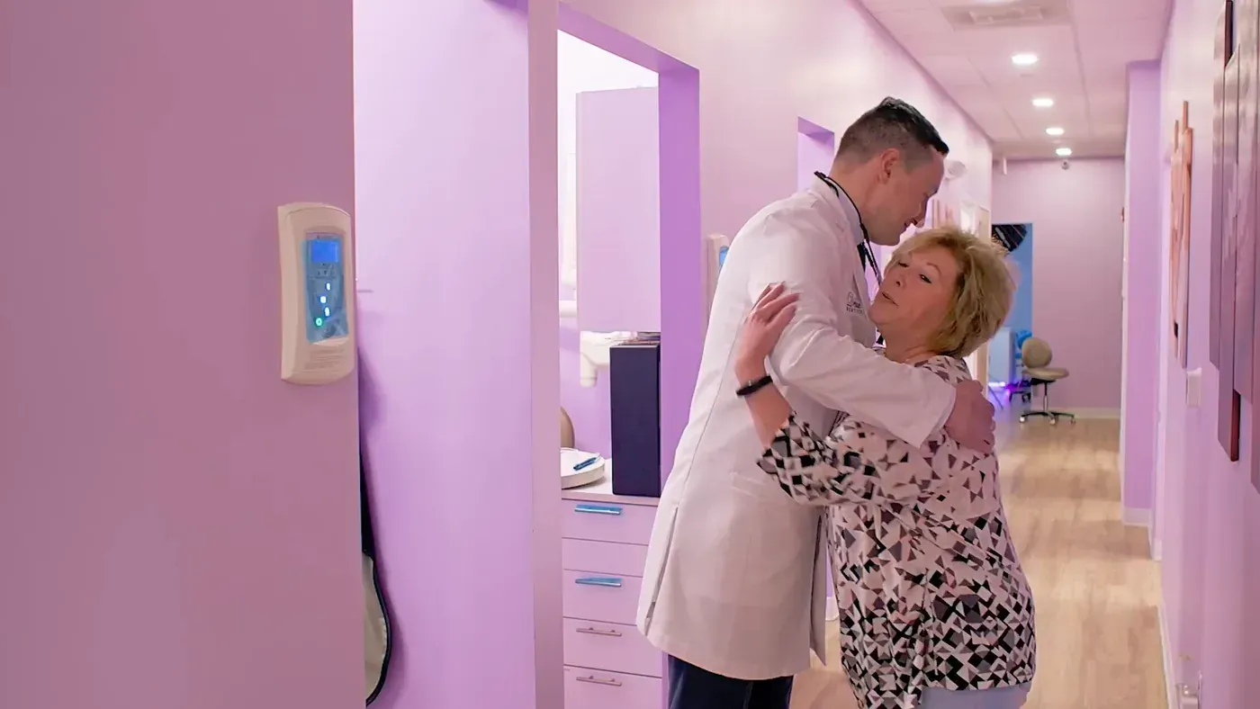 Dr. Godko hugging a once-nervous patient in the hallway, the welcome anxious patients find when they share what worries them