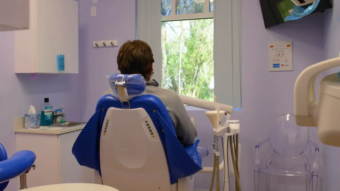 Patient relaxing in a treatment chair by a window before a frenectomy consultation