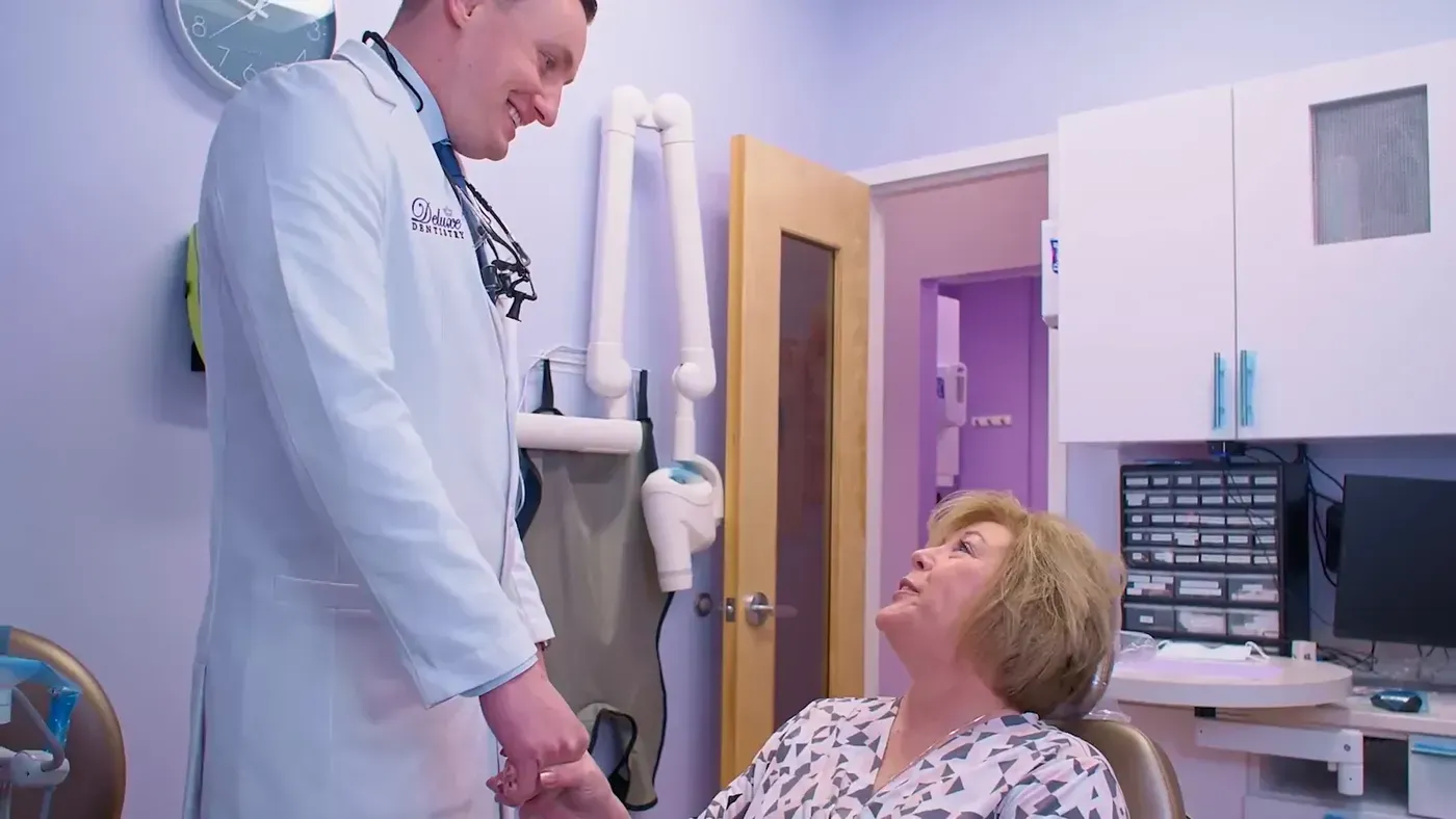 Dr. Maxim Godko holding a patient’s hand chairside before a simple tooth extraction