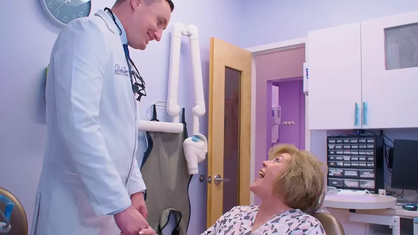 Dr. Maxim Godko sharing a laugh with a patient in the chair as they go over her dental exam