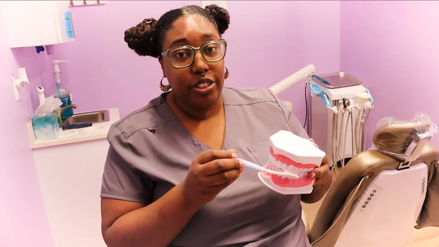 Teeth Cleaning: Deluxe hygienist showing the right way to brush on a model of the teeth