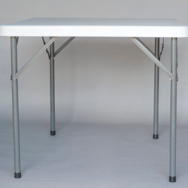 White folding table with metal legs on a plain gray background