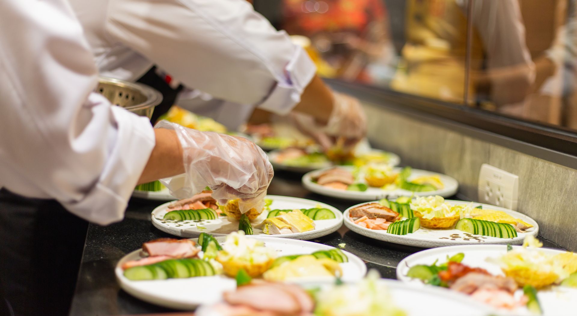 Chef preparing plated salads at a restaurant counter