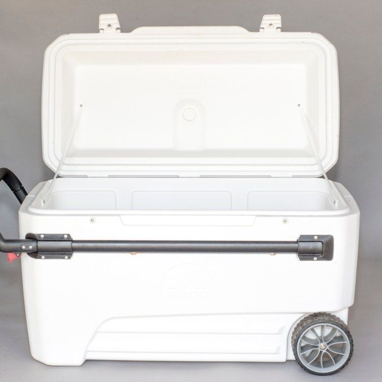 White wheeled cooler with an open lid and black handle.