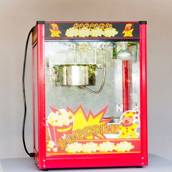 Red toy cotton candy machine with clear chamber and colorful cartoon decals