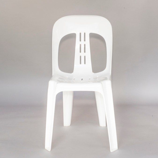 White plastic chair against a plain gray background