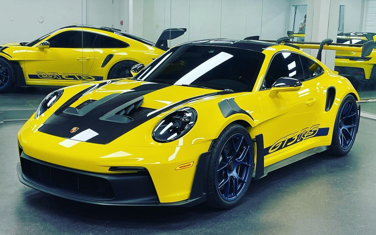 Bright yellow Porsche 911 GT3 RS sports car with black accents.