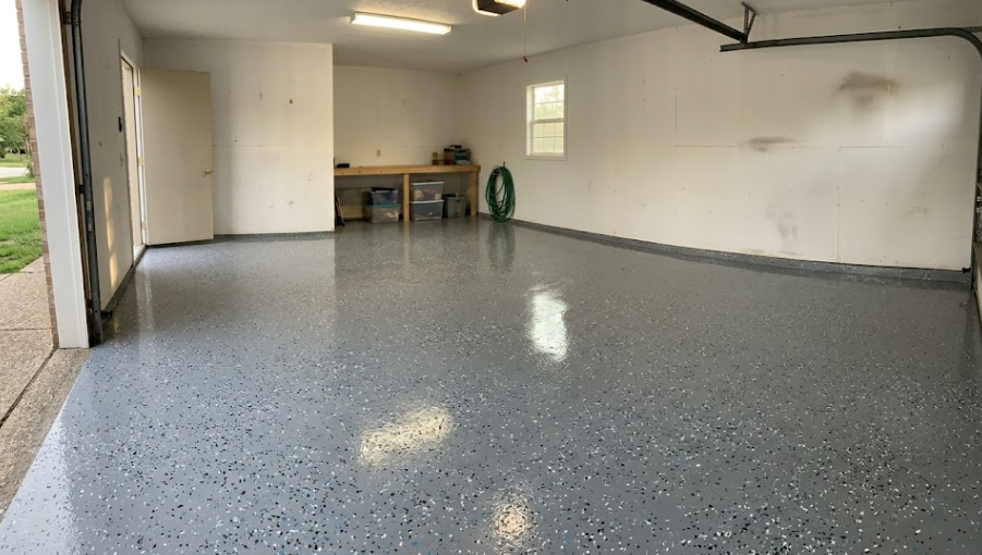A freshly installed, bright gray and blue epoxy garage floor coating in a residential home.