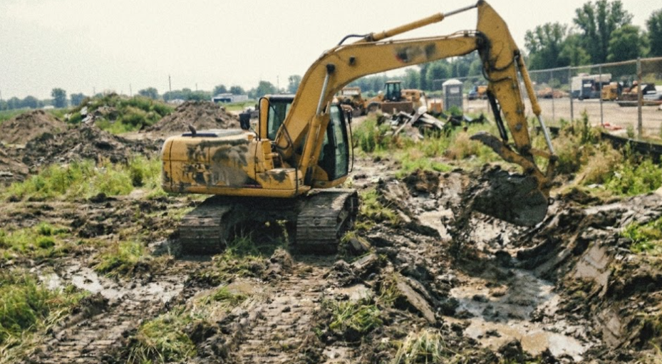 A yellow excavator digging a trench on a construction site in the Shenandoah Valley.