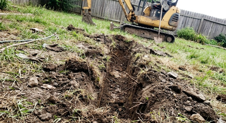 A straight trench dug by an excavating contractor for underground utilities.